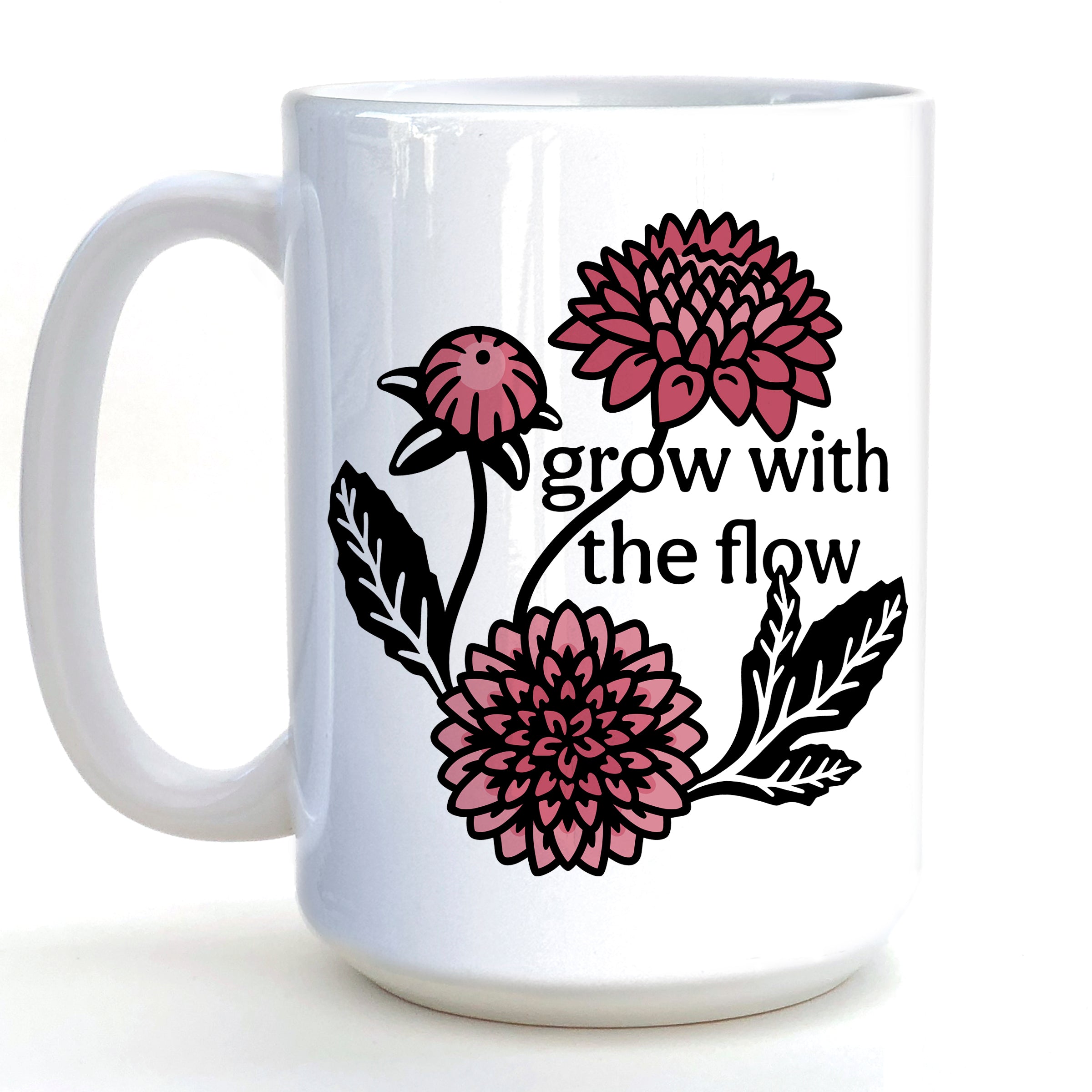 A white ceramic mug with a floral design featuring pink and black flowers and the text "grow with the flow" printed on it.