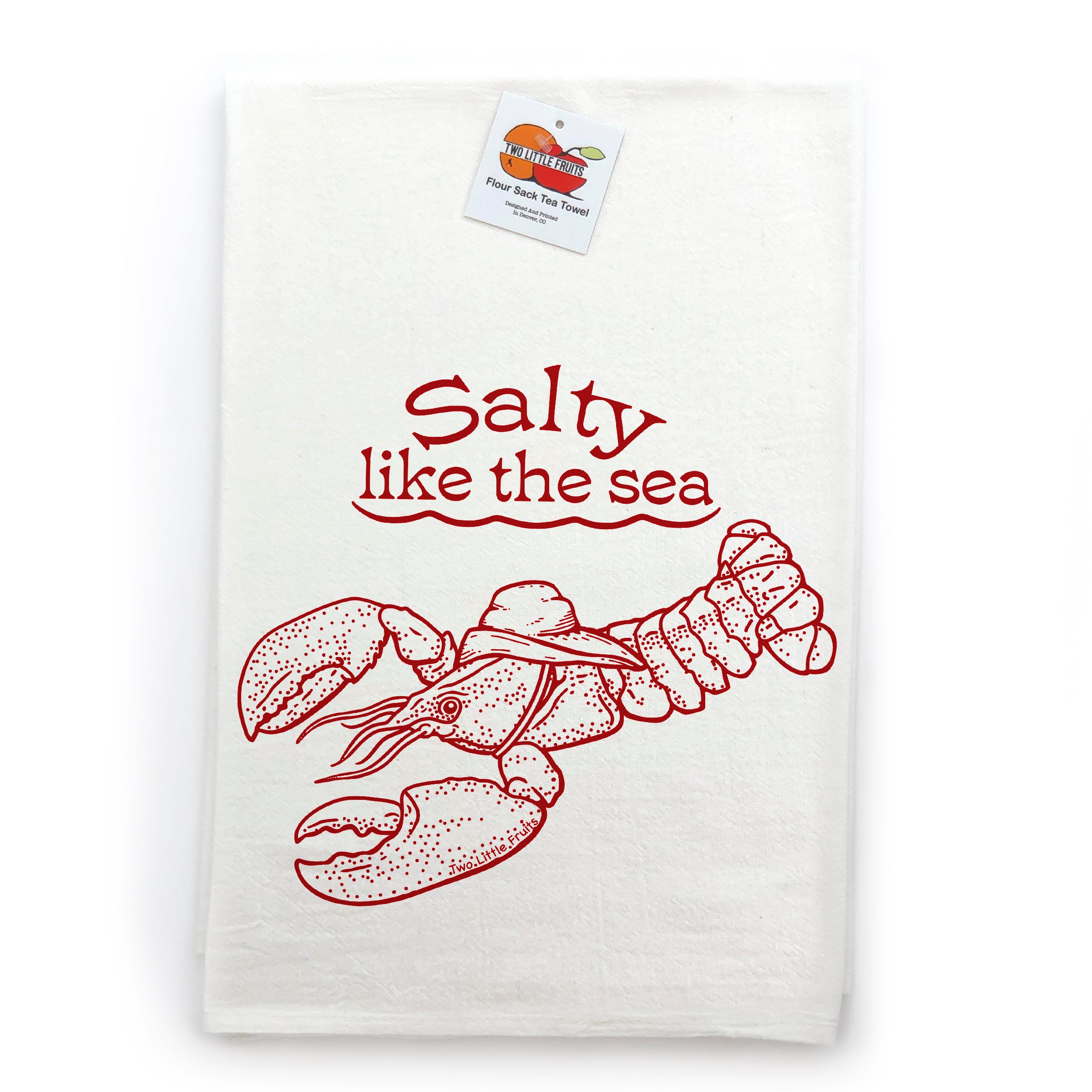 A white towel with a red illustration of a lobster and the text "Salt like the sea" printed on it.
