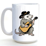 A white ceramic mug with a cartoon image of a furry opossum playing a guitar.