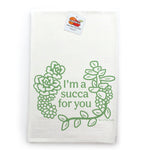 A white towel with a green graphic design featuring a wreath of succulent plants and the text "I'm a succa for you" printed on it.