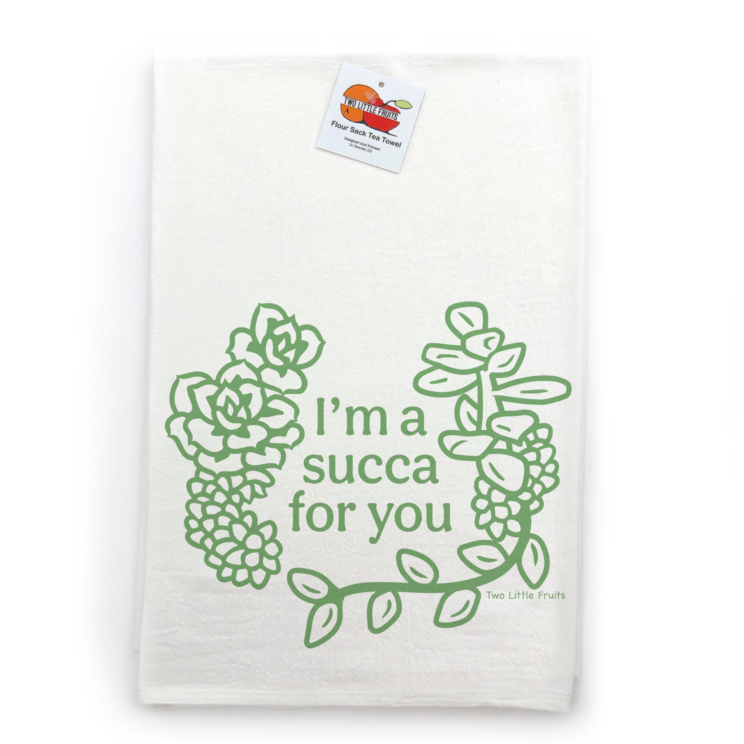 A white towel with a green graphic design featuring a wreath of succulent plants and the text "I'm a succa for you" printed on it.