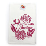 a white towel with a maroon design depicting flowers and the text "grow with the flow" printed on it.