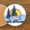 Bear Ceramic Coaster – 4" Adorable Drink Coaster with Cork Backing featuring a vibrant bear design amidst trees and a sunset.