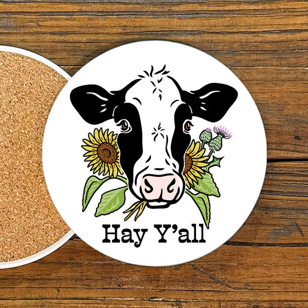 Bright and playful Hey Y'all Cow Drink Coaster by Two Little Fruits featuring a cartoon cow with sunflowers, perfect for adding farmhouse style to your coffee table. Ideal farmhouse style coasters for any decor. Coasters, new.