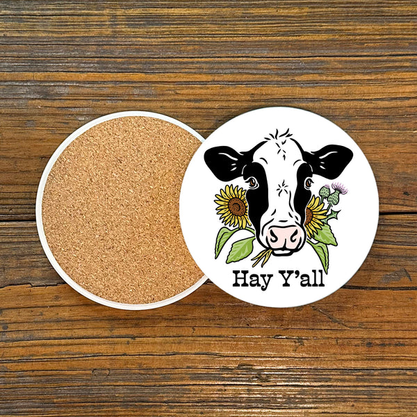 Charming Hey Y'all Cow Drink Coaster by Two Little Fruits showcasing a cow surrounded by sunflowers, ideal for a farmhouse aesthetic. These farmhouse style coasters uplift your drinkware game. Coasters, new.