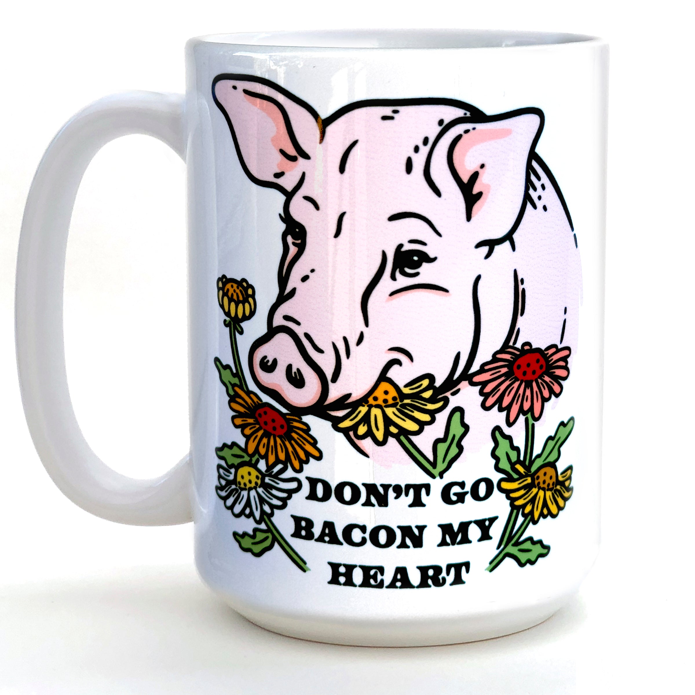 Funny pig coffee mug featuring a cheerful pig illustration surrounded by flowers and the text 'DON'T GO BACON MY HEART'.