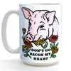 Funny pig coffee mug featuring a cheerful pig illustration surrounded by flowers and the text 'DON'T GO BACON MY HEART'.