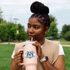 A joyful person sipping from a cup featuring the Protect Transgender Youth Cat Sticker, which boldly states 'Purrtect Trans Youth!' This vibrant sticker represents transgender youth support stickers and promotes LGBTQ PRIDE. A fun and new way to show your support!
