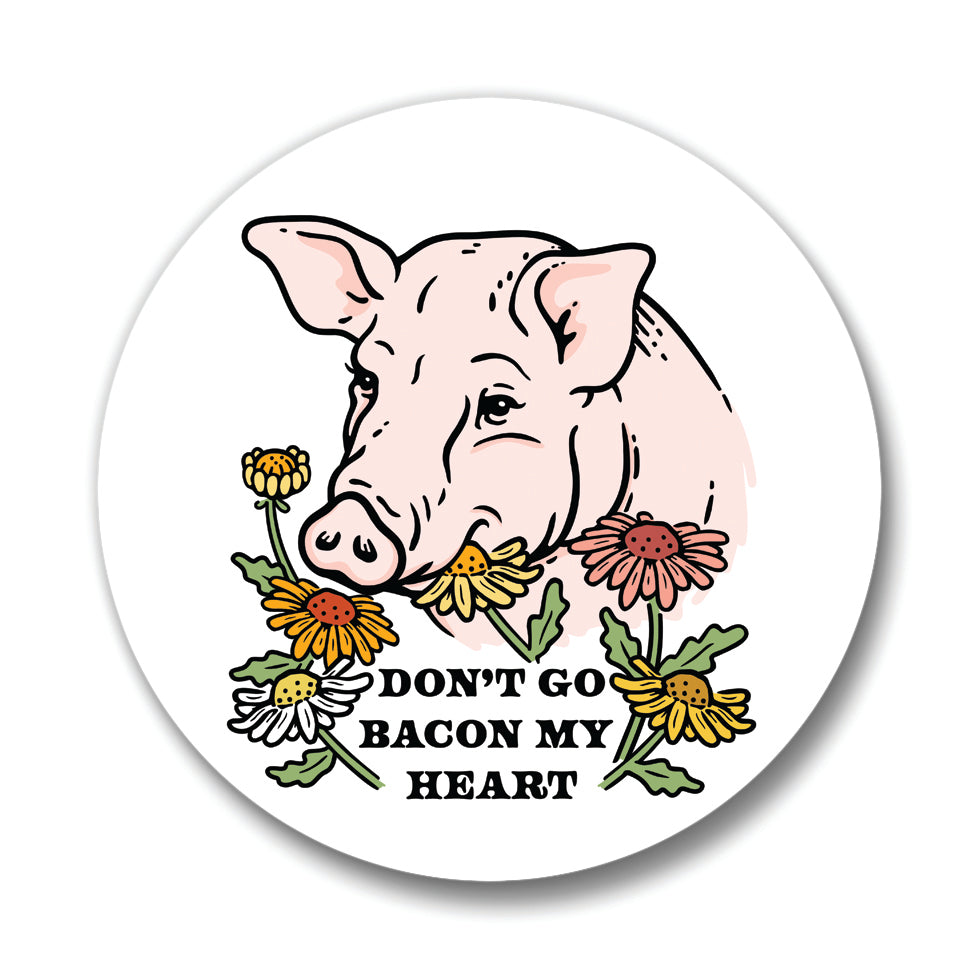 Stylish pig themed coaster displaying an adorable pig illustration adorned with flowers and the text 'DON'T GO BACON MY HEART'. A playful addition to any drink.