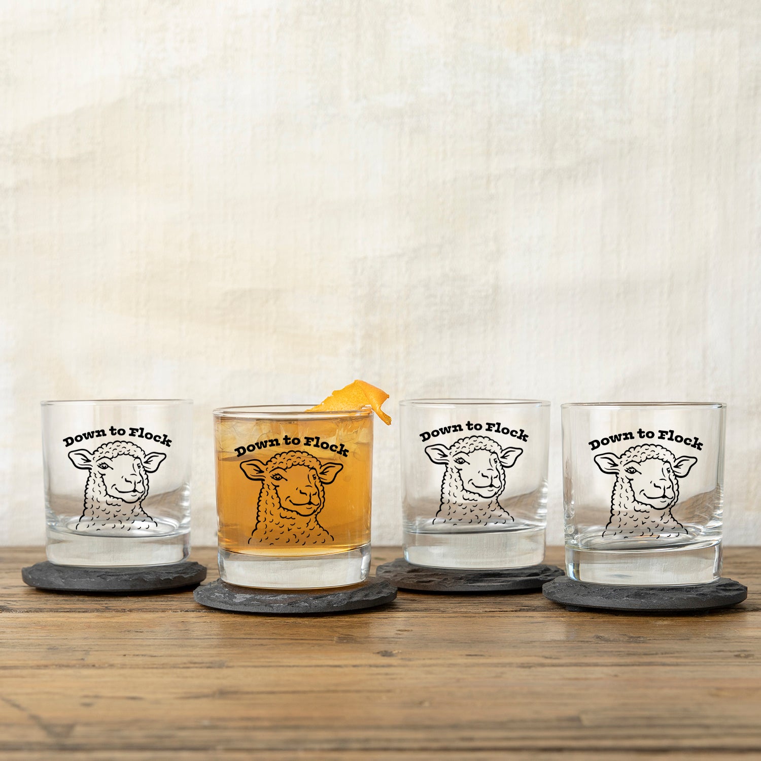 Set of four Funny Lamb Whiskey Glasses featuring the lamb design with the phrase 'Down to Flock,' perfect for entertaining.