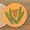 a round coaster with an illustration of green asparagus stalks and the text "Just the tip" written on it.
