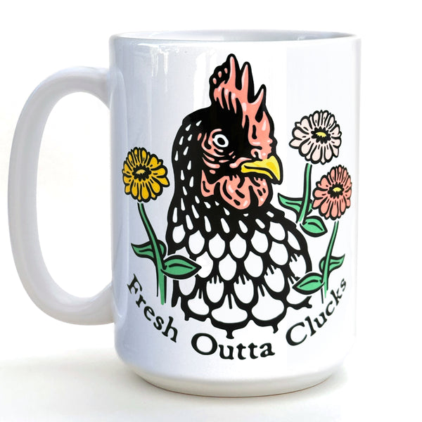 A white ceramic mug with a colorful illustration of a rooster surrounded by flowers and the text "Fresh Outta Clucks" printed on it.