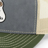 A close-up view of a gray fabric with a white mesh panel on the side, showing the stitching and texture of the material.