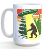 A white ceramic mug with a graphic design depicting a silhouetted figure walking through a forest, with a large green alien spacecraft hovering above.