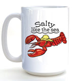 A white ceramic mug with a printed design of a red lobster wearing a yellow hat and the text "Salt like the sea" printed on it.