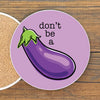 A purple coaster with a cartoon image of a purple eggplant and the text "don't be a" printed on it.