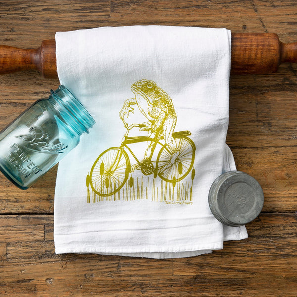 Cheerful and whimsical Frog Tea Towel design with a hand-illustrated frog riding a vintage cruiser bicycle, ideal for any kitchen.