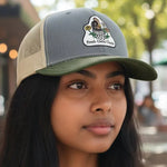 Woman wearing a cap with a logo in an outdoor setting