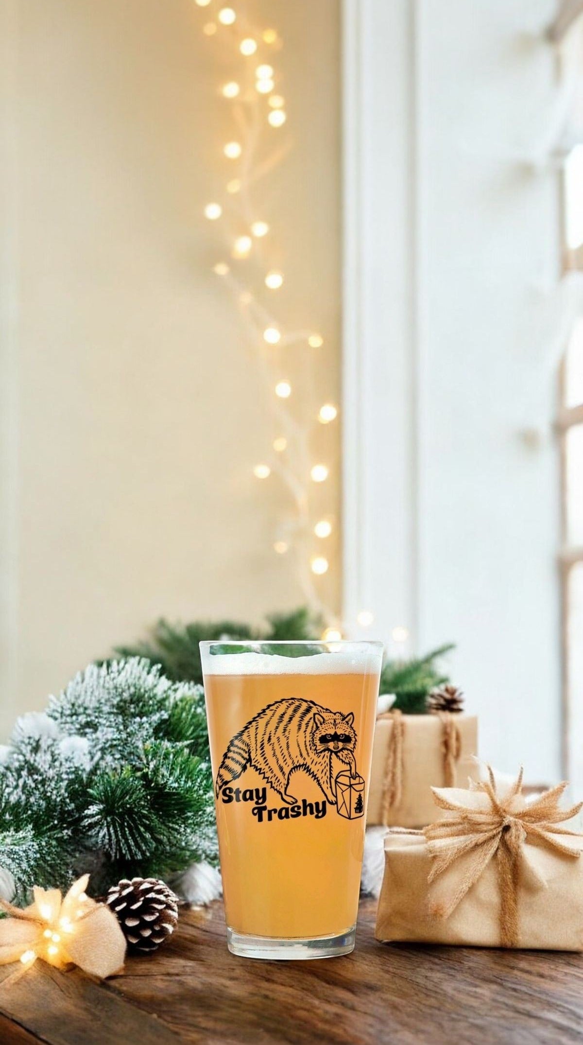 Stay Trashy raccoon pint glass with kraft paper gifts and pine for the holidays