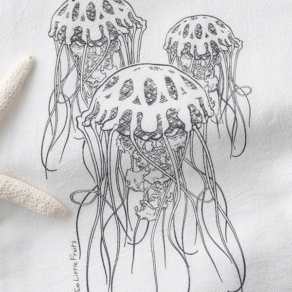 Hand-drawn jellyfish illustration on a white tea towel, showcasing three jellyfish with flowing tentacles, designed by Two Little Fruits.