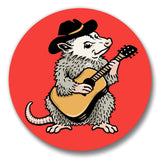 A cartoon opossum wearing a cowboy hat and playing a guitar.