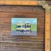 Sleepin' Around Fridge Magnet featuring a vintage yellow camping trailer with a rainbow backdrop, perfect for adding personality to your refrigerator.