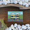 Sleepin' Around Fridge Magnet showcasing a charming yellow camping trailer against a serene green landscape, ideal for decorative purposes.