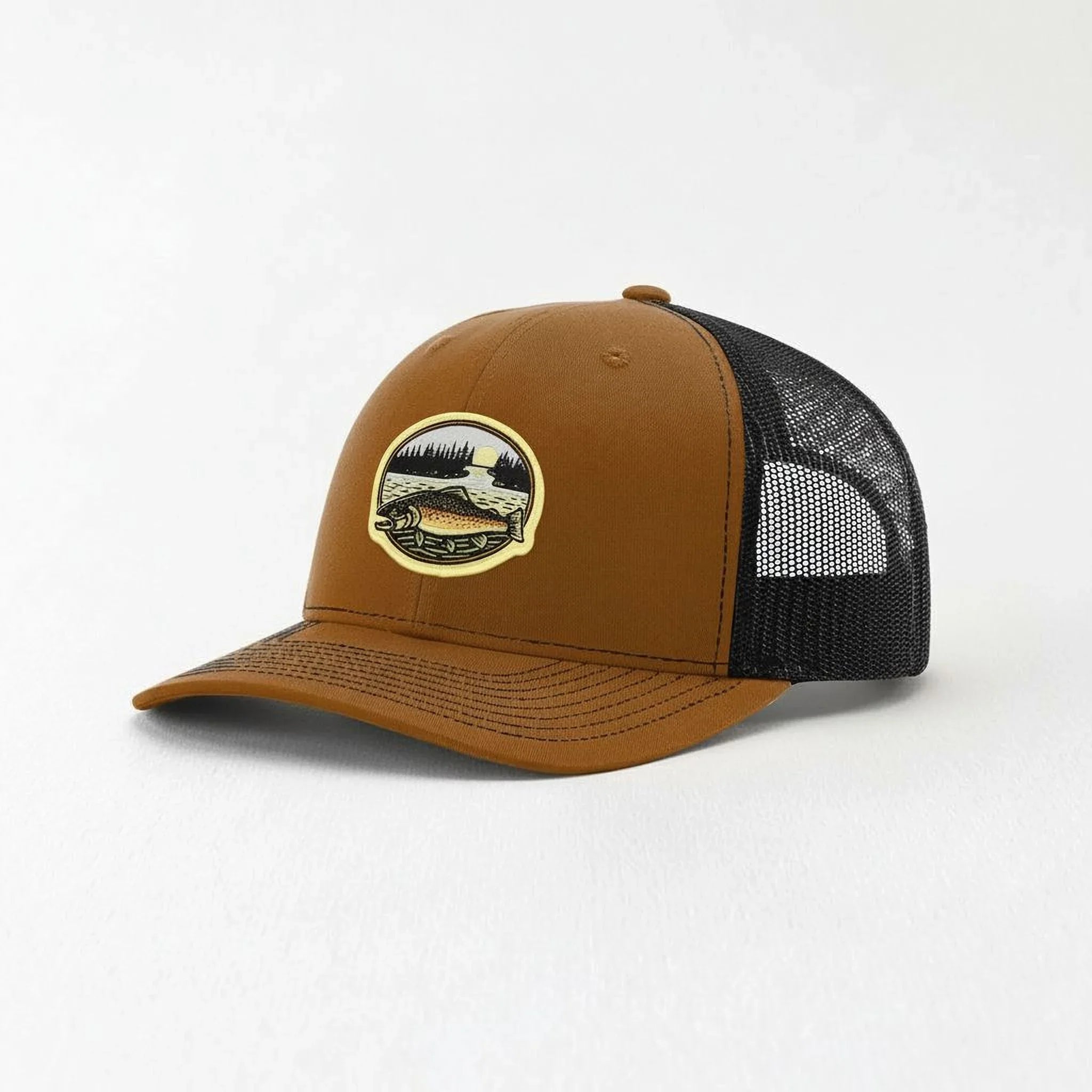 A brown baseball cap with a black mesh panel on the side, featuring a patch with a scenic landscape design.