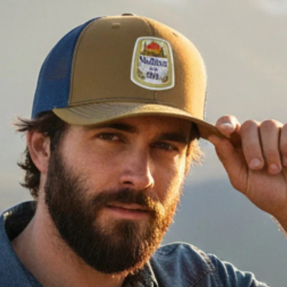 Man with a backpack and cap in front of mountains
