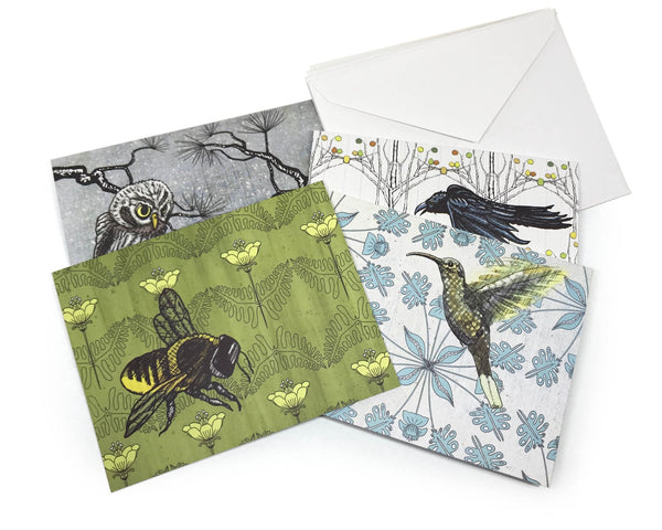 A set of four nature-themed greeting cards featuring illustrations of owls, bees, crows, and hummingbirds, displayed with matching envelopes.