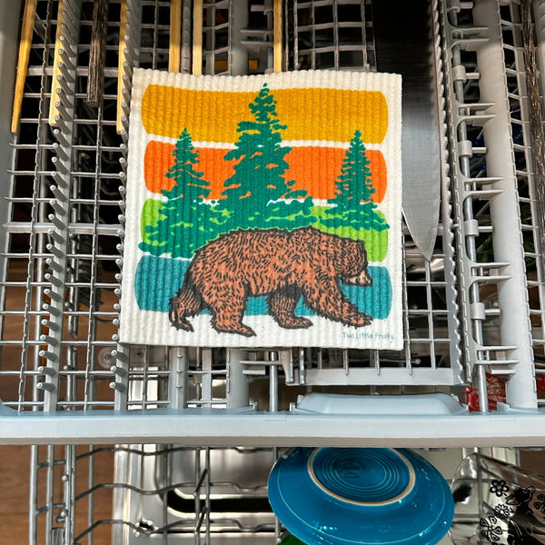 Swedish dishcloth featuring a bear in a dishwasher, illustrating its durability and ease of cleaning in a practical setting.