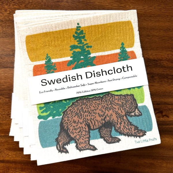 Stack of Swedish dishcloths featuring a bear design, showcasing their eco-friendly packaging and colorful, artistic pattern.