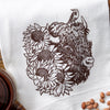 Elegant colorful tea towel featuring a blue longhorn steer decorated with flowers, presented with a tag on a white backdrop.