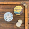 A camping bottle opener alongside a magnetic cap catcher, featuring playful designs, perfect for outdoor enthusiasts.