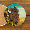 A vibrant, unique coffee table coaster featuring a detailed illustration of a buffalo surrounded by sunflowers, with a bird perched on its head, perfect for adding personality to your home decor.
