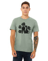 A cheerful man wearing a cat graphic t-shirt featuring a bold design of two cats and monstera leaves, in heather sage color, perfect for cat lovers.