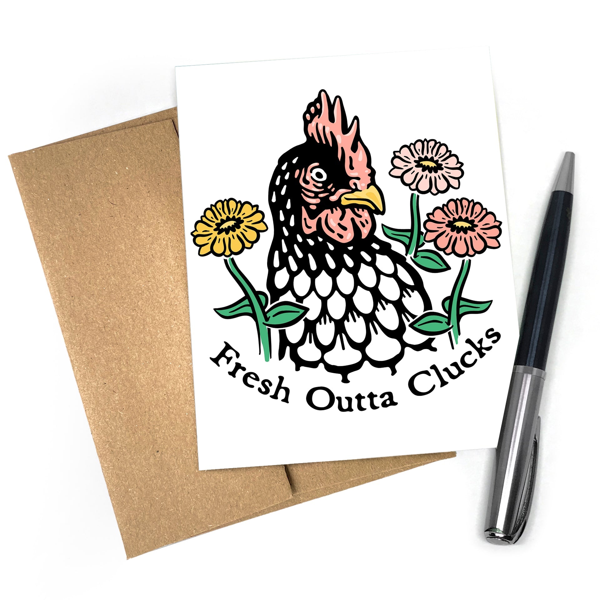 A chicken greeting card featuring an illustrated chicken with flowers, labeled 'Fresh Outta Clucks', alongside a brown envelope and a pen.