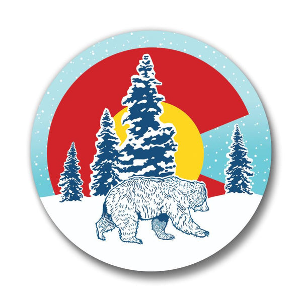 Close-up view of a Colorado flag pin showcasing a bear and evergreen trees, with a blue sky background.