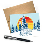 Cute Animal Cards: Winter Bear Blank Greeting Card A2 Size with Envelope featuring a walking bear with a colorful sunset and snowy pine trees in the background.
