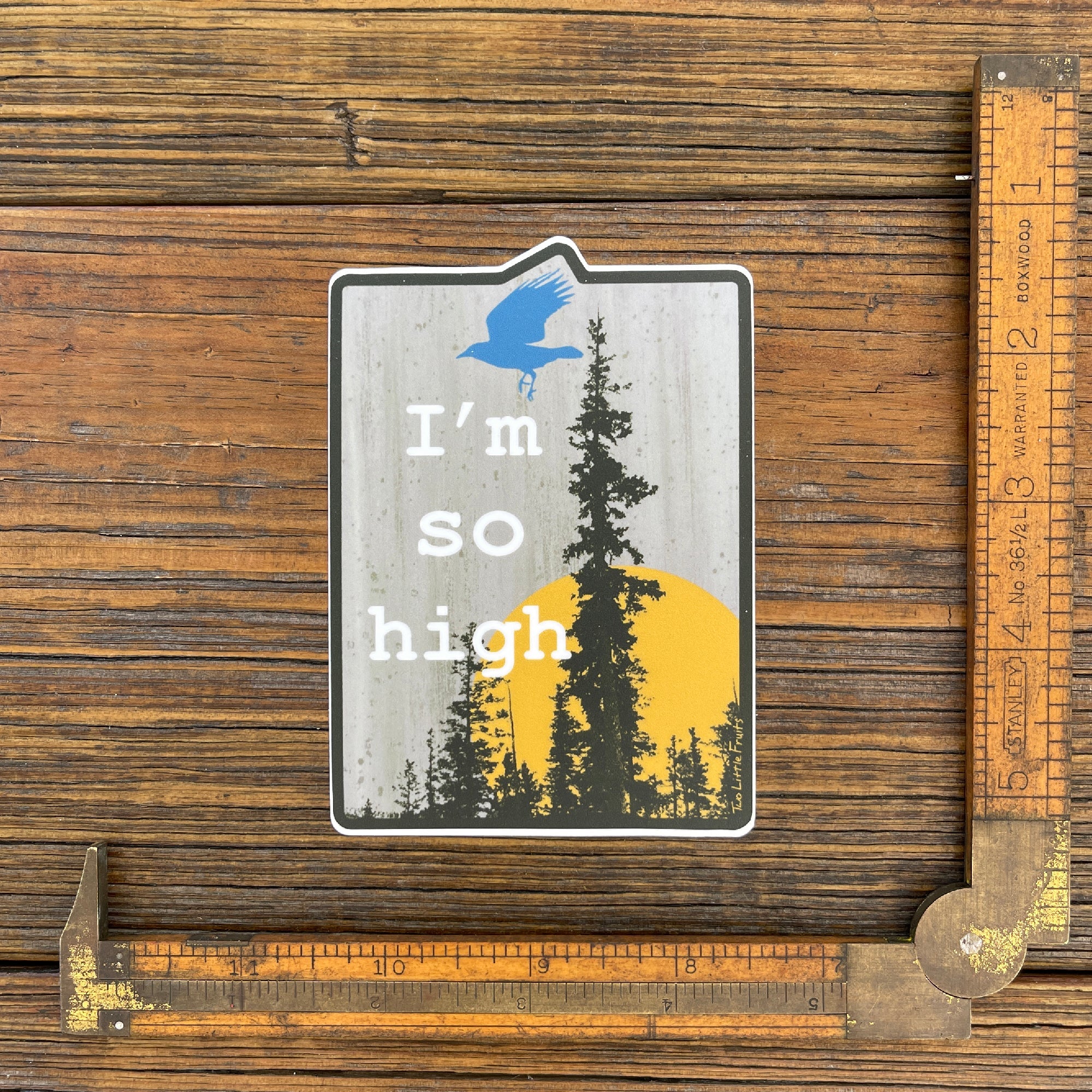 Funny cannabis sticker placed next to a ruler for size reference, showcasing the design of a raven flying with 'I'm So High' text and a forest background.