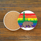 Colorful Gay Bear Drink Coaster showcasing a playful bear and rainbow scenery, perfect for adding a fun touch to your decor, 4-inch ceramic coaster.