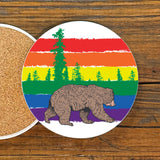 Gay Bear Drink Coaster featuring a vibrant rainbow striped design with a bear walking under colorful trees, 4-inch ceramic coaster by Two Little Fruits.