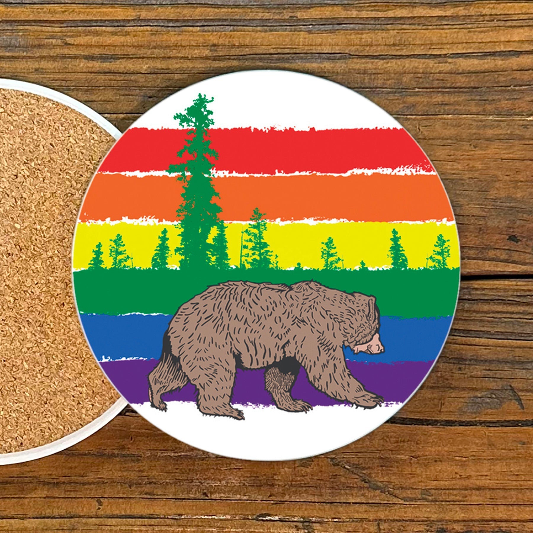 Gay Bear Drink Coaster featuring a vibrant rainbow striped design with a bear walking under colorful trees, 4-inch ceramic coaster by Two Little Fruits.
