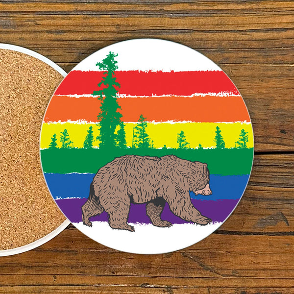 Gay Bear Drink Coaster featuring a vibrant rainbow striped design with a bear walking under colorful trees, 4-inch ceramic coaster by Two Little Fruits.
