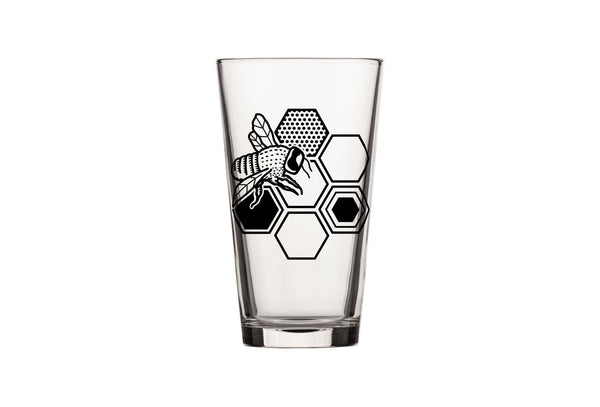 A single bee beer glass featuring a detailed illustration of a bee and honeycomb, ideal for enjoying your favorite beverages.