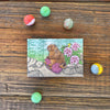 Fun Knitting Marmot Magnet design with a cute marmot, pink yarn, and flowers, surrounded by colorful marbles, ideal for adding personality to your refrigerator while holding important notes!