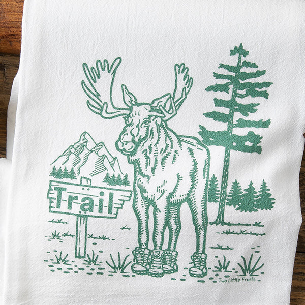 Moose Kitchen Towel featuring a whimsical illustration of a moose in boots, surrounded by a pine tree and mountains, perfect for adding charm to any kitchen with cotton kitchen towels.