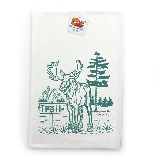 Moose Kitchen Towel displayed with a tag, featuring an adorable moose wearing boots in a scenic backdrop, a delightful addition to your collection of cotton kitchen towels.