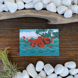Artistic octopus fridge magnet showcasing a playful red octopus against a scenic backdrop, ideal for holding notes and adding charm to your fridge.