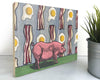 Pig and Bacon 8x10 Wood Art Block featuring a whimsical pink pig illustration amidst a colorful background of bacon and eggs, perfect for enhancing your farmhouse decor wall art.